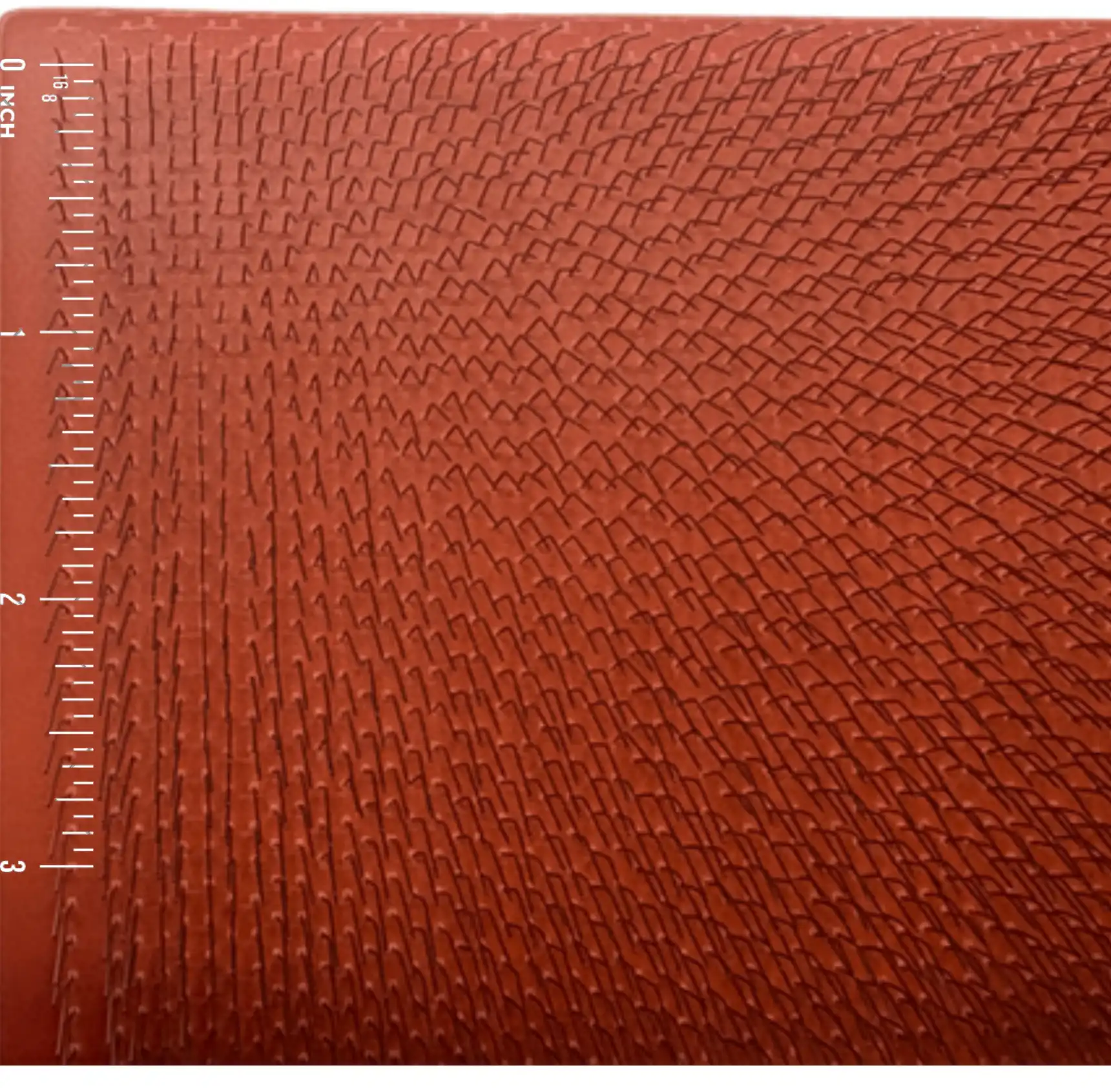 Close-up of 120 TPI carding cloth with an inch scale for size comparison.