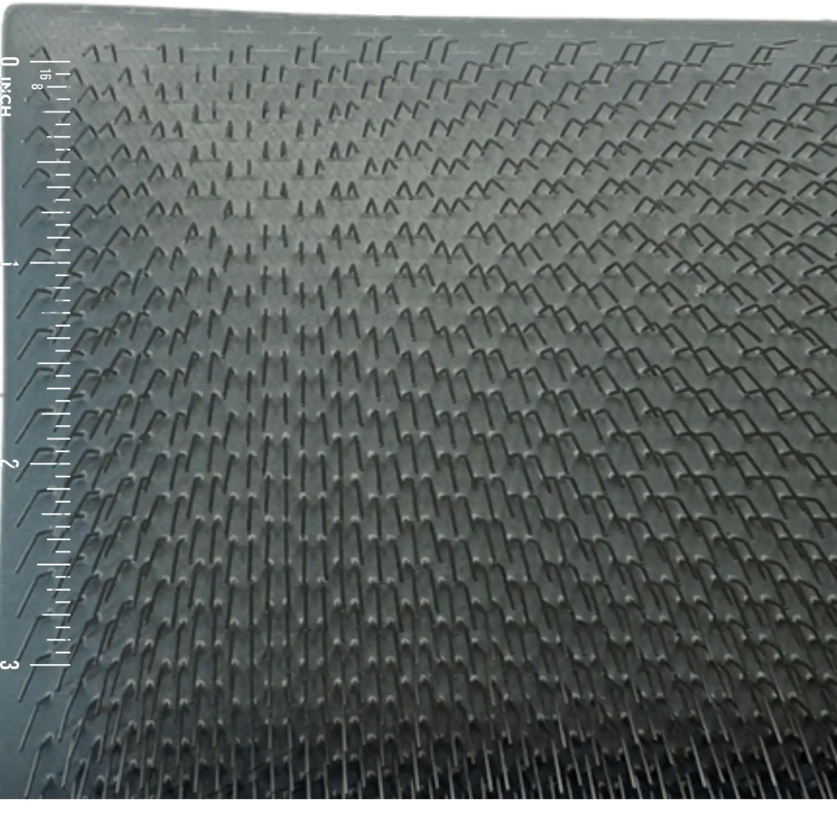 Close-up of 72 TPI carding cloth with an inch scale for size comparison.